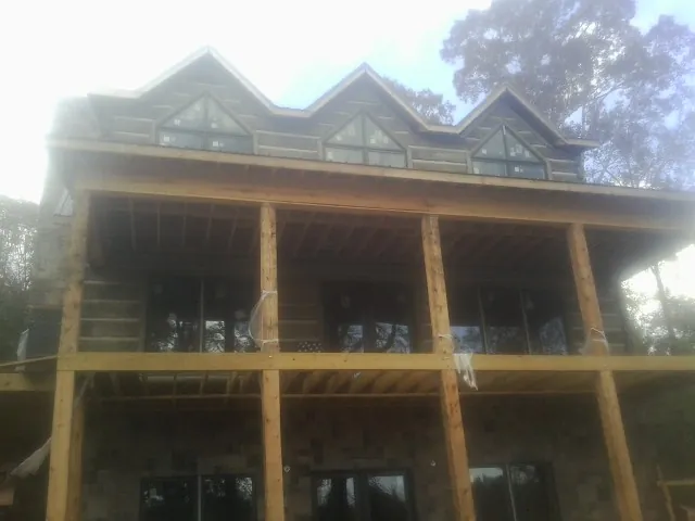 Dormers and porch framing on a large log home under construction — Roof Coating work by our crew in Ohio City