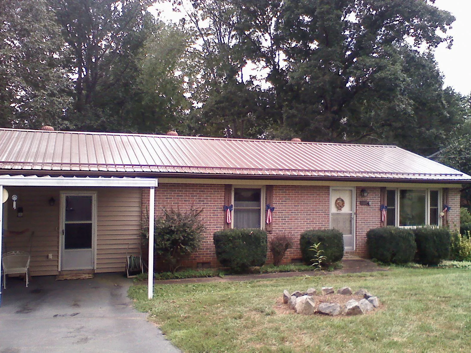 Bronze metal roof and carport on a brick ranch home — Roof Repair work by our crew in Ohio City