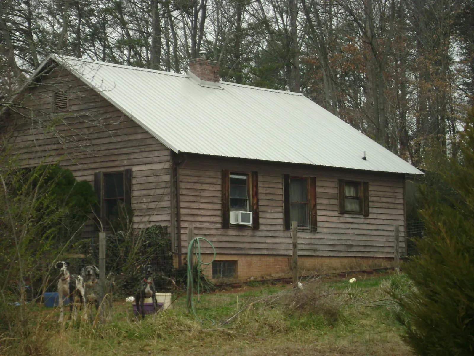 White metal roof on an old wood sided farmhouse, from a Metal Roof Installation job in Ohio City